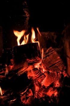 bright flame of fire burns in a fireplace in the old house in winter evening