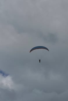 A person paragliding on a cloudy day, Solitaire, clouds, vertical, colourful, risk sport