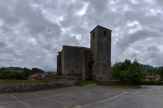 Church of San Pedro in Lierganes, on a cloudy day.No one, sky with grey storm clouds, lonely, stone walls, panoramic view