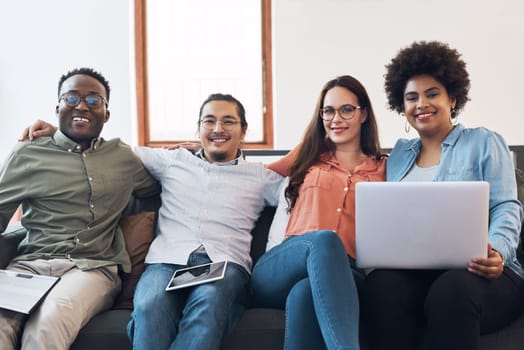 We work together, we chill together. a group of young businesspeople having a meeting on a sofa in a modern office