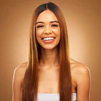 Haircare, beauty and portrait of woman in studio for growth and color shine or healthy texture. Aesthetic female happy smile for hair, natural self care and hairdresser or salon on brown background.