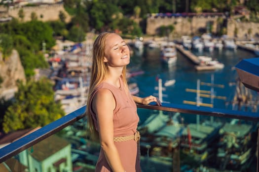 Woman tourist in Old town Kaleici in Antalya. Turkiye. Panoramic view of Antalya Old Town port, Taurus mountains and Mediterrranean Sea, Turkey.