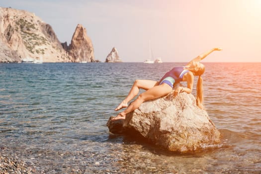 Woman travel sea. Young Happy woman in a long red dress posing on a beach near the sea on background of volcanic rocks, like in Iceland, sharing travel adventure journey