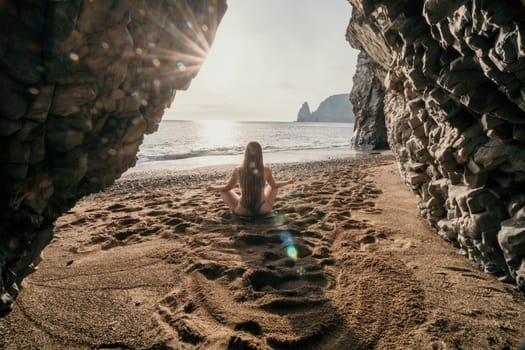 Middle aged well looking woman with black hair doing Pilates with the ring on the yoga mat near the sea on the pebble beach. Female fitness yoga concept. Healthy lifestyle, harmony and meditation.