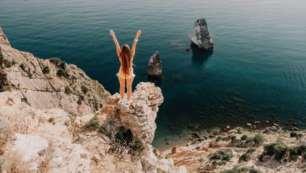 Woman travel sea. Happy tourist taking picture outdoors for memories. Woman traveler looks at the edge of the cliff on the sea bay of mountains, sharing travel adventure journey.