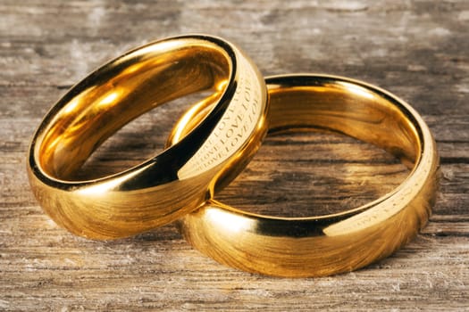 Two golden wedding rings on wooden background