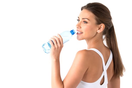 Young beautiful fit woman drinking water after exercise