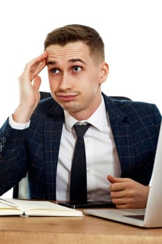 sad businessman using laptop, sitting on chair at desk, having problems thinking about troubles in office