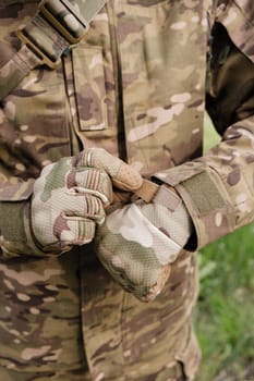 Preparing for Action: Close-up of Camouflaged Tactical Gloves being Fastened by Military Personnel