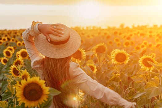 Woman in the sunflowers field. Summer time. Young beautiful woman standing in sunflower field.