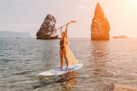 Close up shot of beautiful young caucasian woman with black hair and freckles looking at camera and smiling. Cute woman portrait in a pink bikini posing on a volcanic rock high above the sea