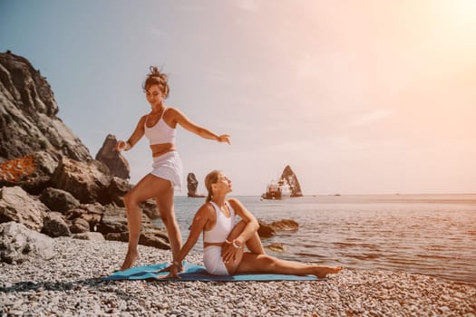 Woman sea yoga. Back view of free calm happy satisfied woman with long hair standing on top rock with yoga position against of sky by the sea. Healthy lifestyle outdoors in nature, fitness concept.