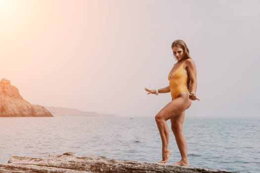 Woman meditating in yoga pose silhouette at the ocean, beach and rock mountains. Motivation and inspirational fit and exercising. Healthy lifestyle outdoors in nature, fitness concept.