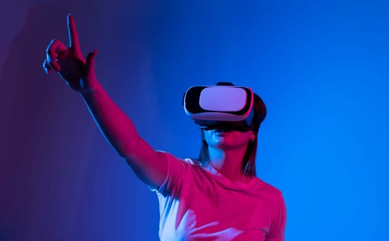 Brunette woman in a black top wearing virtual reality goggles in modern coworking studio