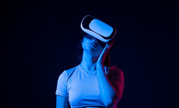 Brunette woman with VR headset touching something what she see in virtual world. Futuristic technology. Woman with glasses of virtual reality. Future technology concept