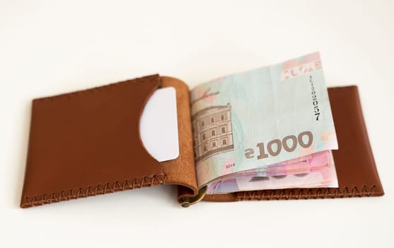 Ukrainian hryvnia money in leather money clip, wallet. Ukraine money on white background with. Currency of Ukraine. Accessories. Money, financess, economy, saving