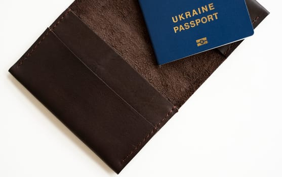 Ukrainian biometric passport id on a leather passport cover to travel the Europe without visas on the table. Inscription in Ukrainian Ukraine Passport