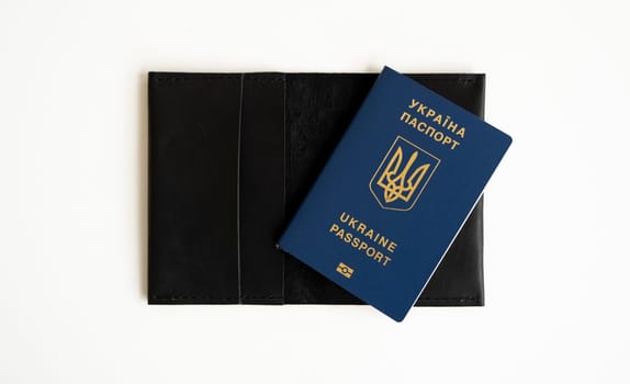 Ukrainian biometric passport id on a leather passport cover to travel the Europe without visas on the table. Inscription in Ukrainian Ukraine Passport