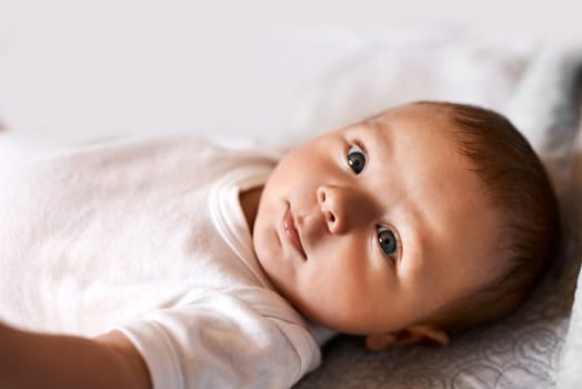 You dont get more adorable than this. an adorable baby boy lying down on a bed at home