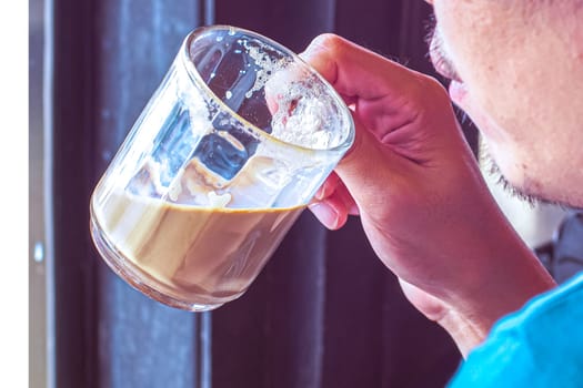 Pleasant man drinking hot latte coffee human action still life