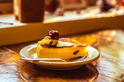 A delicious slice of cheesecake with chocolate topping and redcurrant