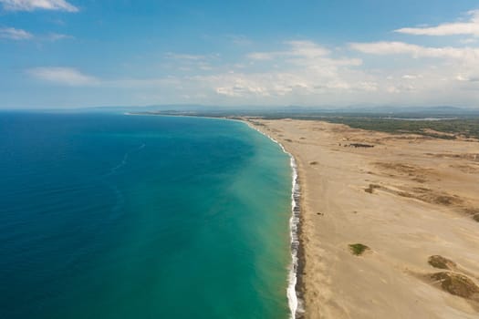 Top view of sandy beach and blue ocean. Paoay Sand Dunes, Ilocos Norte, Philippines.