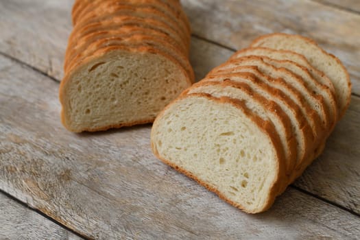 White bread cut into slices on wooden background