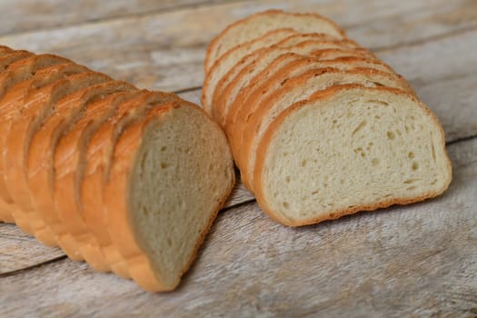 White bread cut into slices on wooden background