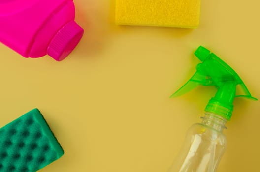 Cleaning. Flat lay Bottles with cleaning product and sponges on a yellow background. Cleaning supplies, top view.