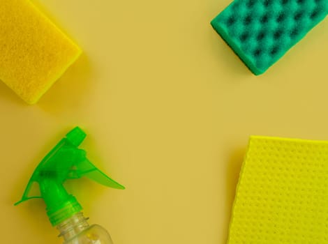 Cleaning. Flat lay Bottle with cleaning product, sponges and rag on a yellow background. Cleaning supplies, top view.
