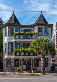 SAVANNAH, USA - DECEMBER 02, 2011: an old historic house decorated with flowers and a palm tree in the foreground in Savannah