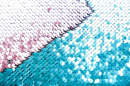 Sequins close-up macro. Abstract background with blue sequins and lilac color on the fabric. Texture scales of round sequins