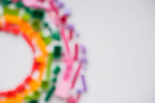 blurred, defocused plastic bricks and blocks on white background ,top view ,space for text.