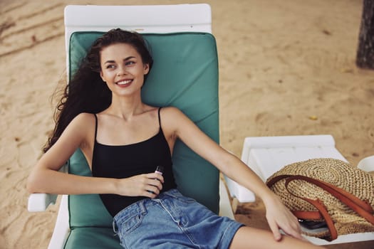 water woman long chair sand sun chair beach hair exotic beach smiling sea sunglasses ocean sunbed resort bikini enjoy rest person lifestyle lying