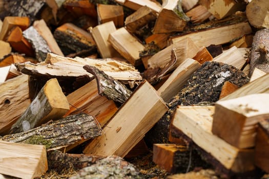 Dry chopped firewood in a pile. Abstraction and background.