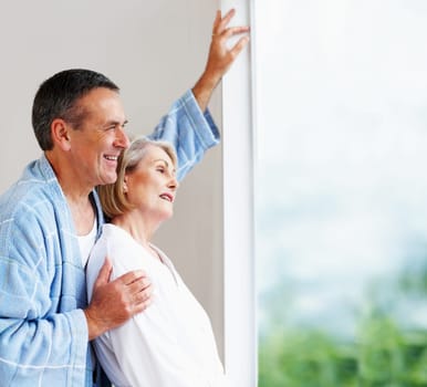 Romantic mature couple looking through window. Portrait of a romantic mature couple looking through window