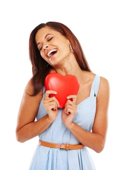 Romantic at heart. Young woman holding a red heart and smiling against a white background
