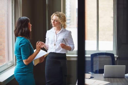 Effective communication makes for a productive team. two businesswomen having a discussion in an office