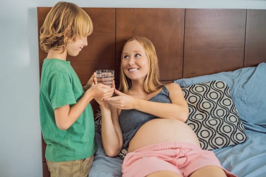 Son brought his pregnant mother a glass of water.