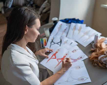 Caucasian woman draws sketches of sportswear using watercolors