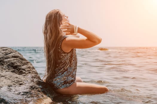 Woman travel sea. Young Happy woman in a long red dress posing on a beach near the sea on background of volcanic rocks, like in Iceland, sharing travel adventure journey