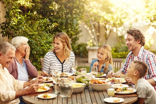 This is what familys all about. a family eating lunch together outdoors