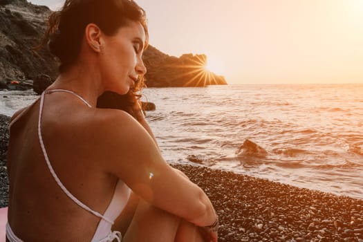 Woman sea yoga. Back view of free calm happy satisfied woman with long hair standing on top rock with yoga position against of sky by the sea. Healthy lifestyle outdoors in nature, fitness concept.