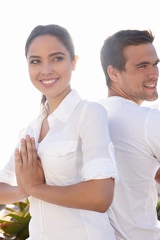 Shes glad to have him near. a young man and woman doing yoga outdoors