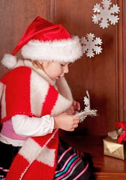 child in a suit of Santa Claus in the room decorated to new year