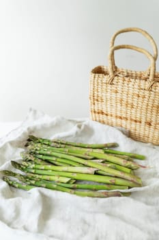 Fresh sliced asparagus on a white background. View from above. Vegan and very healthy healthy food. Farmer's harvest, going to the market. Straw basket