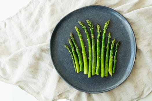 Close-up on a large plate - asparagus with salt and garlic. Delicious and healthy food, served in a restaurant, beautiful layout