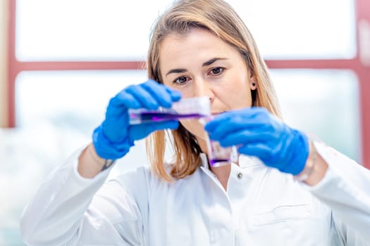 young attractive female scientist examines chemical samples of substances and drugs in a research laboratory. High quality photo