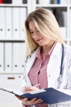 Female medicine doctor hand hold jar of pills and write prescription to patient at worktable. Panacea and life save, prescribing treatment, legal drug store concept. Empty form ready to be used