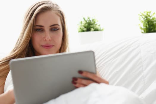 young blond beautiful woman work winh laptop stay in bed early morning